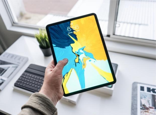 person, der holder ipad pro