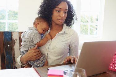 Mãe com bebê trabalhando no escritório em casa
