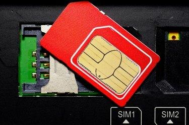 Punainen SIM-kortti matkapuhelimen paikoissa.