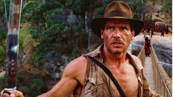 Harrison Ford sostiene una espada en Indiana Jones y el Templo Maldito.