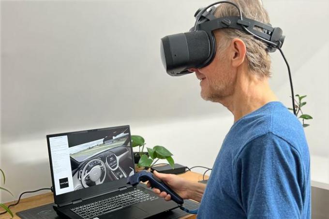 Alan Truly sitzt vor einem Laptop und trägt das Varjo Aero VR-Headset.