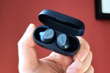 Jabra Elite 4 v otevřeném nabíjecím pouzdře drženém rukou.