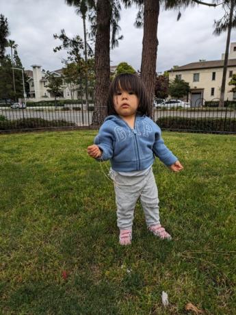 Criança parada em um parque tirada com a câmera principal do Google Pixel 7a