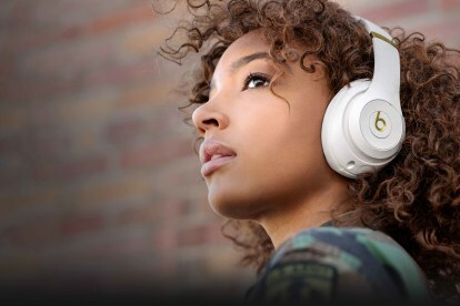 Beats Studio 3 ワイヤレス ヘッドフォンの白バージョンを着用している女の子。