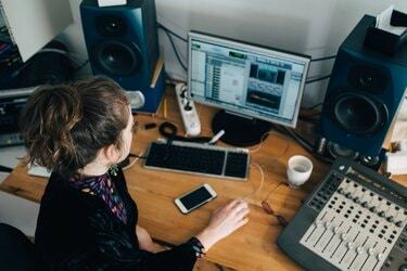 Visão de alto ângulo do músico usando o computador na mesa do estúdio