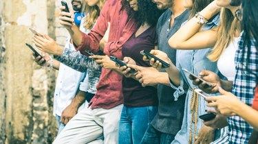 बाहर स्मार्टफोन का उपयोग करने वाले बहुसांस्कृतिक दोस्तों का समूह - मोबाइल स्मार्ट फोन के आदी लोग - जुड़े हुए पुरुषों और महिलाओं के साथ प्रौद्योगिकी अवधारणा - विंटेज फिल्टर टोन पर क्षेत्र की उथली गहराई