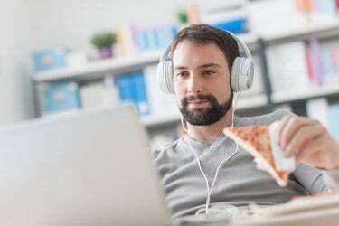 Homem navegando na net e fazendo um lanche