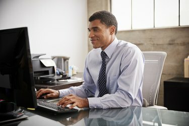 Biznesmen rasy mieszanej używający komputera w biurze