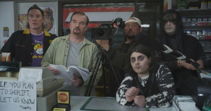 Pemeran Clerks III berdiri di belakang konter saat syuting sebuah adegan.