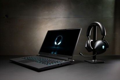 كمبيوتر محمول طراز Alienware m17 R5 يجلس بجوار سماعة رأس.