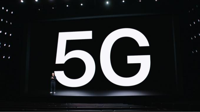 Tim Cook, az Apple vezérigazgatója az 5G kifejezés hatalmas vetülete előtt. 