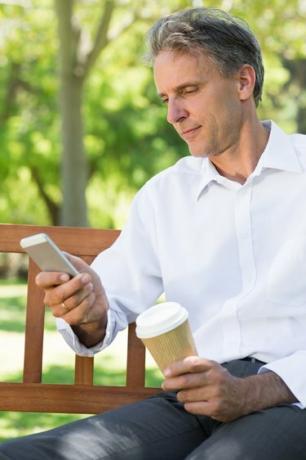 Бізнесмен за допомогою мобільного телефону в парку
