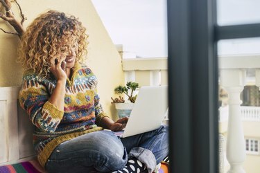 cheio de imagem colorida para mulher de meia-idade trabalhando a liberdade no laptop ao ar livre no terraço, plantas e natureza em segundo plano para o conceito de independência. escritório em casa e conectar-se com o resto do mundo e amigos