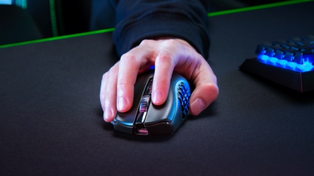 한 남자의 손이 검정색 바탕 화면에 Naga 2 Pro 게임 마우스를 들고 있습니다.