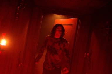 يقف تاي سيمبكينز في مدخل أحمر في فيلم Insidious: The Red Door.