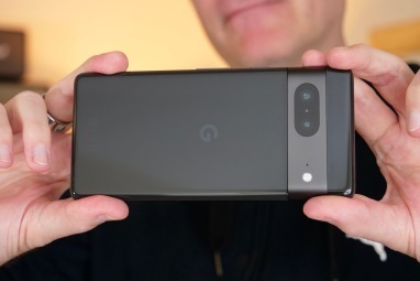 Mann som holder Google Pixel 7 som et kamera.