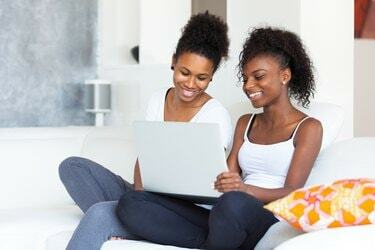 Afroamerikanska studentflickor som använder en bärbar dator