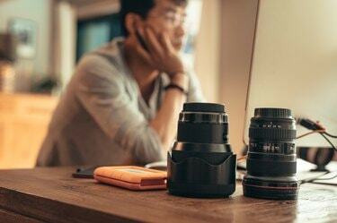 Fotograaf die foto's bewerkt met lenzen op tafel