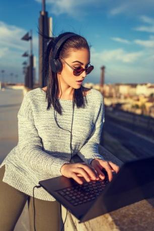 امرأة شابة محب يكتب على الكمبيوتر المحمول في الهواء الطلق