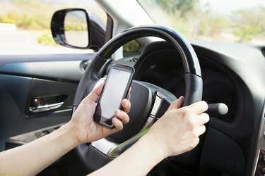 смарт телефон в ръка по време на шофиране