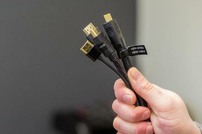 Три кабелі HDMI тримав хтось у руці.