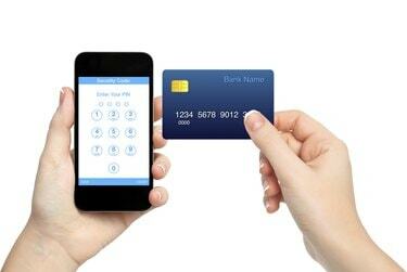 mãos femininas segurando um telefone e um cartão de crédito