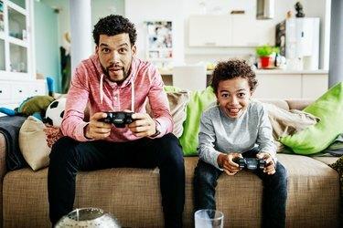 비디오 게임을 함께 하는 동안 집중하는 아버지와 아들