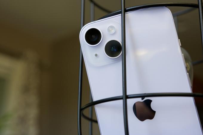 Un iPhone 14 sprijinit în interiorul unei lămpi decorative.