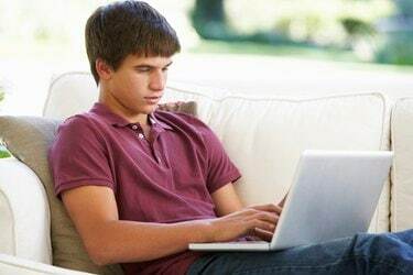 الولد المراهق، الاسترخاء، عن، الأريكة، على البيت، الاستعمال، laptop