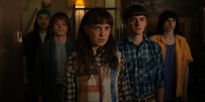 Eleven, Will, Mike a Jonathan stojí a hledí na statický snímek ze 4. sezóny Stranger Things.