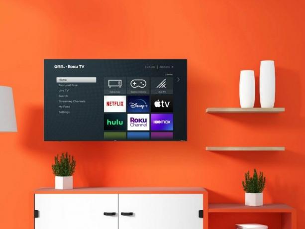 Onn. 75” Class 4K UHD (2160P) LED Frameless Roku Smart TV adalah ruang tamu dengan dinding oranye.
