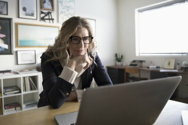 Empreendedor sênior de negócios trabalhando em um laptop no escritório do estúdio