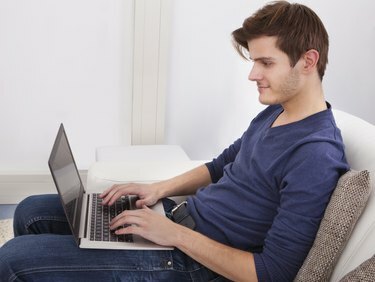 Vyras, naudojantis nešiojamąjį kompiuterį