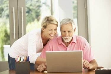 Felnőtt lánya és idősebb apa laptopot használ otthon