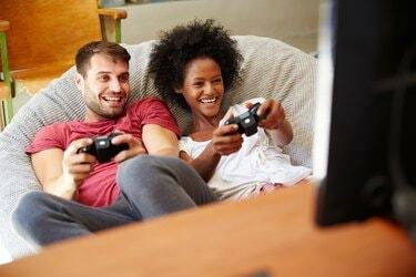 Pareja joven en pijama jugando videojuegos juntos