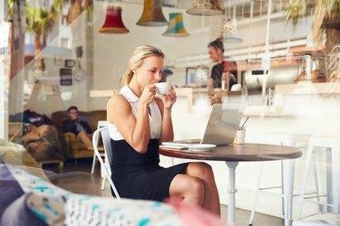 سيدة أعمال تجلس على طاولة في مقهى صغير