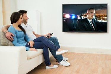 الزوجان السعيدان في غرفة المعيشة يشاهدان الفيلم