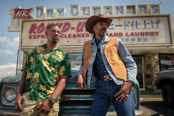 Day Shift의 한 장면에서 Jamie Foxx와 Snoop Dogg가 트럭에 기대어 있습니다.