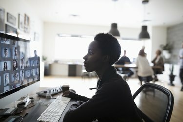 Ženská fotoeditorka kontroluje digitálne fotografické nátlačky na počítači v kancelárii