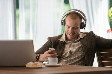 Jovem ouvindo música com fones de ouvido em um café