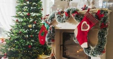 Празан снимак који приказује чаролију празника у мирном снежном божићном јутру: украшен угао у модерној кући са јелком, камином и поклонима. Дом породице која са радошћу слави