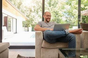 Onnellinen aikuinen mies soittaa videopuhelua kannettavalla tietokoneella