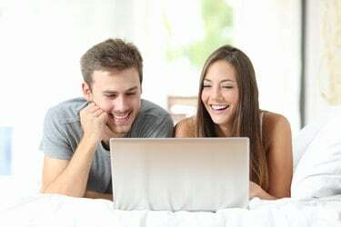 Couple regardant des vidéos sur un ordinateur portable à la maison