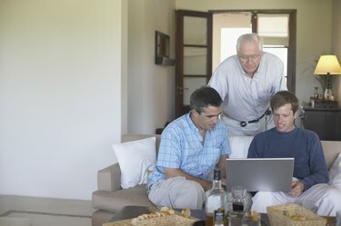 Padre con sus dos hijos mirando un portátil