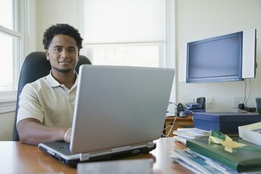 Retrato de um empresário usando um laptop em um escritório