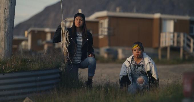 Dve dievčatá, z ktorých jedna drží pušku, sa krčia v poli v scéne zo SlashBacku.