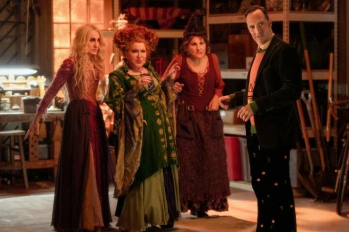 ホーカス ポーカス 2 のシーンでサンダーソン姉妹を演じるサラ ジェシカ パーカー、ベット ミドラー、キャシー ナジミーがトニー ヘイルの近くに立っています。