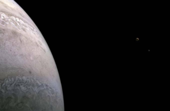 Powiększone zdjęcie przedstawiające księżyc Jowisza Io (po lewej) i Europę (po prawej).