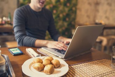 Man sitter i kinesisk restaurang och arbetar på sin bärbara dator