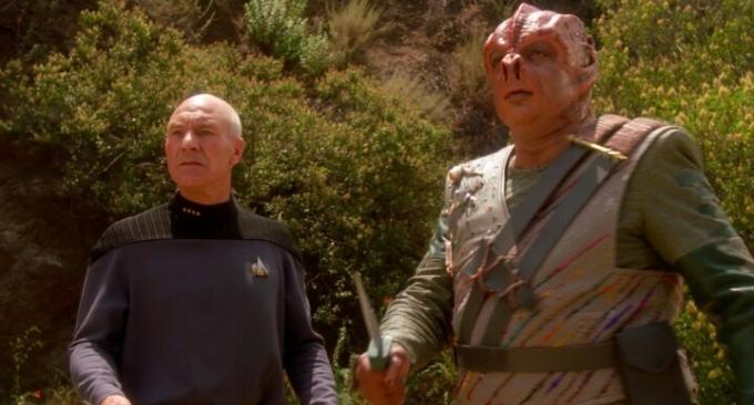 Picard a mimozemšťan stojí venku ve Star Trek: The Next Generation. 